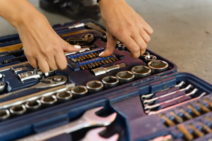 A person touches tools in the tool box